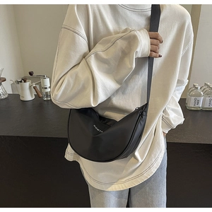 Sac bandoulière demi-lune noir avec lettrage COMTA blanc pour un style décontracté
