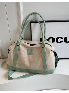 Grand sac de voyage en toile beige avec anses en cuir vert clair et bandoulière amovible
