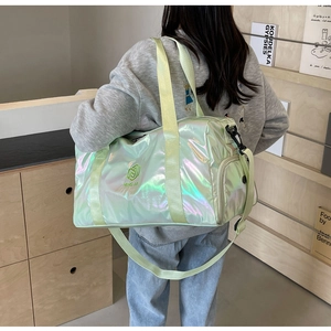 Rear view of model carrying iridescent mint green sports bag with shoulder strap