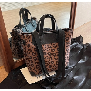 Detail of leopard print tote bag with black leather handle and stylish wide strap