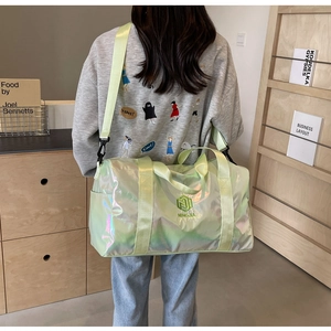Iridescent light green travel bag with handles and adjustable strap shown on model back