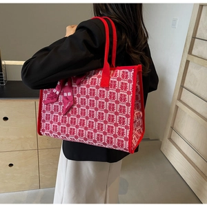 Macro detail of red bridal tote bag featuring traditional double happiness jacquard and silk scarf