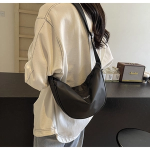 Détail du sac croissant en nylon noir avec bandoulière réglable et logo blanc