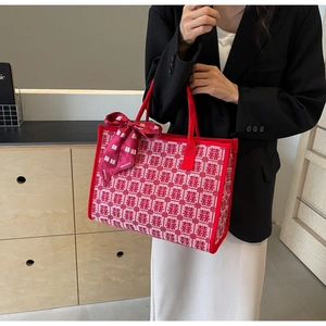 Detailed macro view of festive red knitted tote bag with Xi wedding character patterns