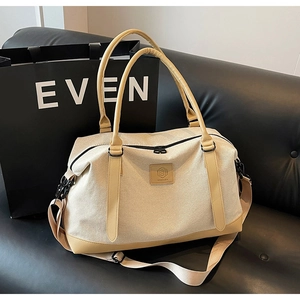 Close-up of stylish canvas travel bag with leather handles and adjustable shoulder strap