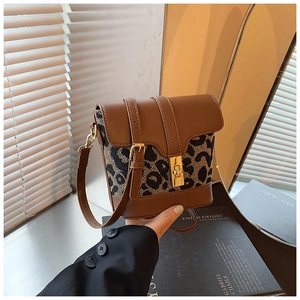 Detail of vintage bucket bag featuring brown leather trim and leopard print with gold lock