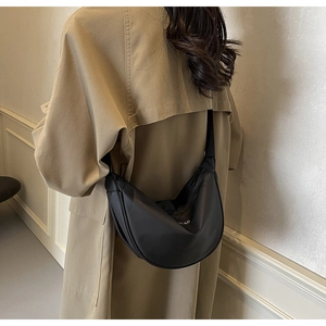 Détail du sac bandoulière noir en forme de croissant avec fermeture éclair et sangle