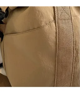 Gros plan du tissu en nylon marron et de la large sangle de ce sac de voyage