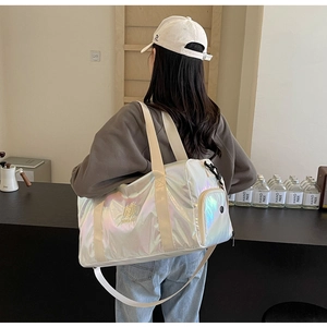 Holographic pearlescent gym bag with durable shoulder strap shown on a model