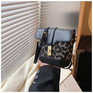 Detailed shot of leopard print bucket bag with gold hardware and contrast stitching