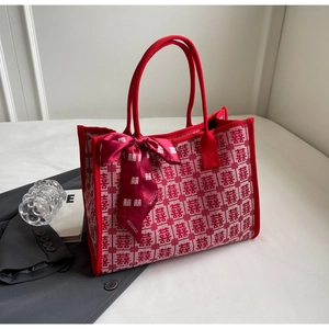 Detail of red wedding tote bag with Xi character patterns and decorative silk scarf