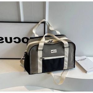 Λεπτομέρεια γκρι τσάντας ταξιδιού με μπροστινή τσέπη και ρυθμιζόμενο ιμάντα ώμου