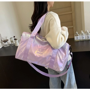 Detail view of the iridescent purple travel bag with branding and adjustable shoulder strap
