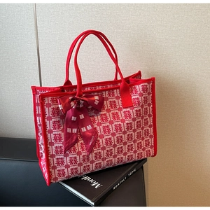 Close-up of red wedding tote bag with woven Xi characters and ribbon detail