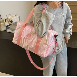 Detail shot of the pink metallic gym bag featuring durable handles and branded logo