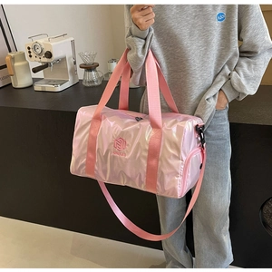 Iridescent pink travel duffel bag with shoulder strap shown in a lifestyle scene