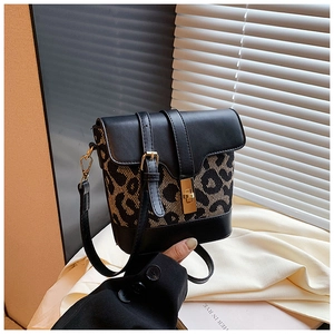 Detail of leopard print bucket bag featuring gold twist lock and black leather stitching