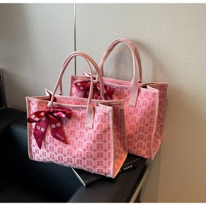 Detail of pink bridal tote bags featuring Double Happiness patterns and red satin ribbons