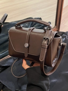 Retro dark brown leather crossbody bag with top handle and round metallic buckle