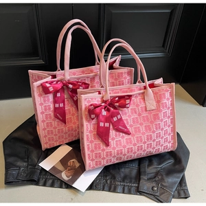 Close-up of pink canvas bridal tote bags with red Xi characters and silk ribbon detail