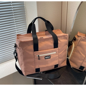 Λεπτομέρεια γκρι-ροζ τσάντας γυμναστηρίου με ανθεκτικό ύφασμα και μπροστινή τσέπη με φερμουάρ