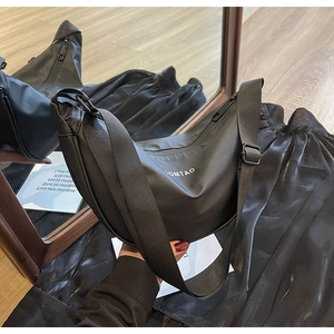 Vues avant et arrière d'un sac bandoulière croissant noir avec logo et sangle large