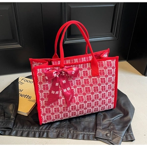 Detail of red bridal tote bag with Xi character jacquard and decorative silk scarf bow