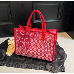 Close-up of red wedding tote bag with Xi character prints and a decorative silk scarf