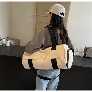 Detail of the cream canvas sports bag with Ningjia embroidery and black carry straps