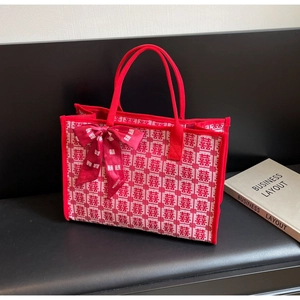 Detail of red wedding tote bag featuring XI character jacquard and bow ribbon handle
