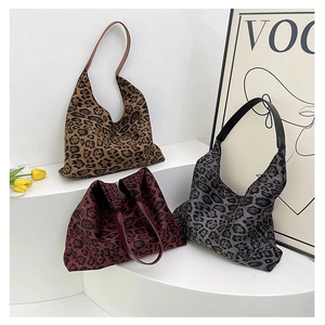 Three leopard print tote bags in brown, red, and grey on a minimalist white display