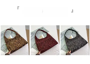 Three leopard print hobo bags in brown, red, and gray displayed on denim fabric