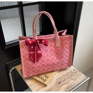 Detail of pink bridal tote bag with Xi character jacquard and red silk ribbon bow