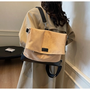 Detail of khaki canvas messenger bag with black leather bottom and adjustable strap