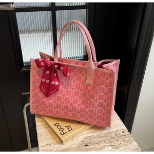 Detail shot of a festive pink bridal tote bag with red Xi characters and silk scarf ornament