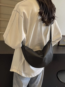 Sac bandoulière demi-lune noir minimaliste avec imprimé ROMTAO porté à l'épaule