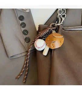 Primer plano de llavero de béisbol con guante y bate en un bolso de cuero marrón suave