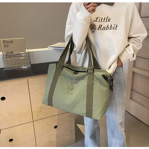 Vue détaillée du sac cabas en toile vert olive avec logo brodé et sangle de transport