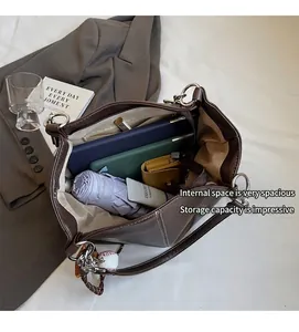 Vista superior del interior espacioso del bolso tote marrón con tableta y objetos diarios
