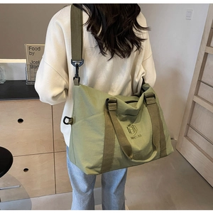 Détail du sac cabas en toile verte avec broderie NNGJIA et large bandoulière en nylon