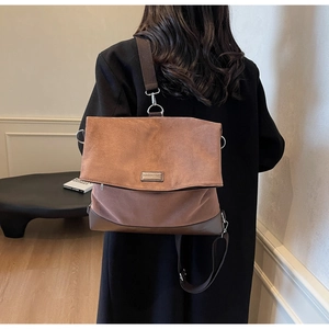 Rear view of a model wearing the brown flap shoulder bag with MOROMORO logo detail