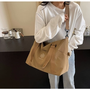 Détail du grand sac de voyage kaki avec logo NINGJIA et bandoulière réglable pratique