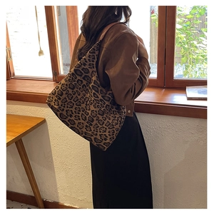 Close-up of leopard print tote bag with brown spots on a soft velvet shoulder strap