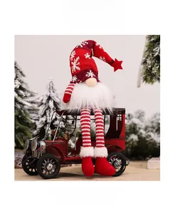 Detail of Christmas gnome with snowflake knit hat sitting on a vintage red car model