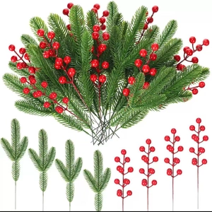 Artificial Christmas tree branches with green pine needles and red berries for holiday decor