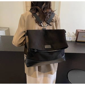 Modern black oversized backpack featuring matte leather texture and silver buckle details