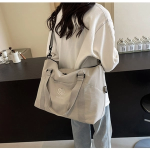 Détail du grand sac de voyage en toile avec poches latérales et bandoulière réglable