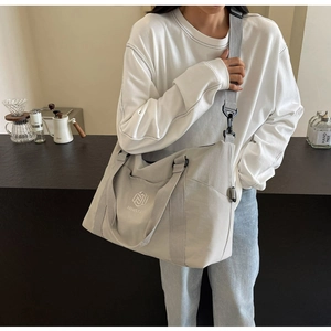 Détail du sac de voyage en nylon gris avec poignées solides et bandoulière réglable