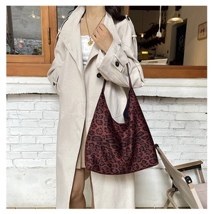 Detail of vintage burgundy leopard print tote bag with wide strap on model in trench coat