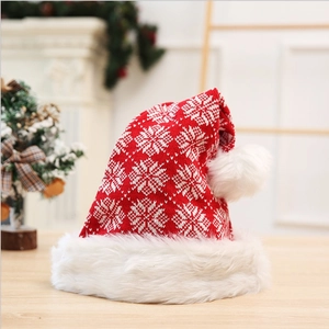 Thick red knitted Christmas hat with white snowflake patterns and plush fur pompom